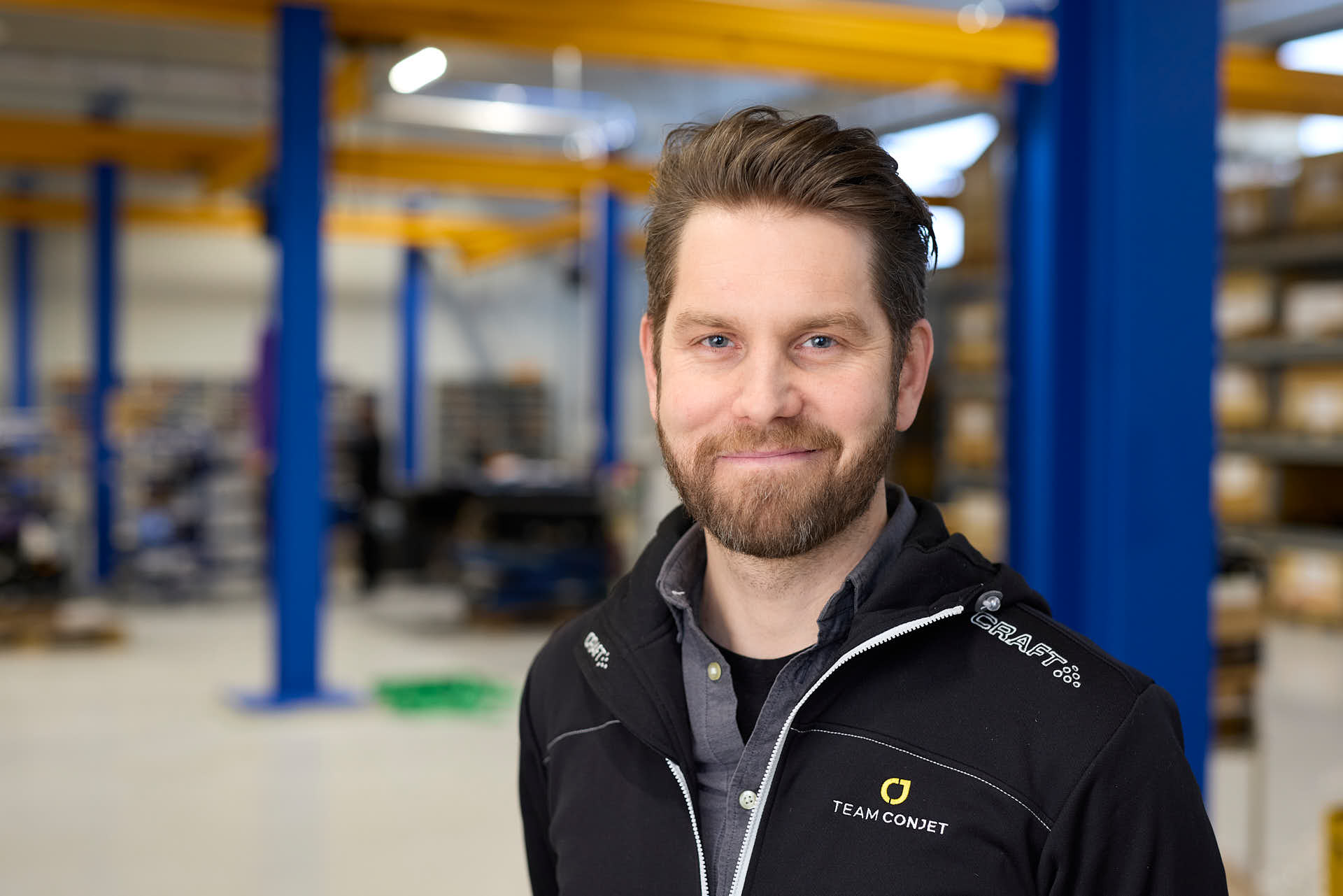 Kundcase för JJ-Gruppen hos Conjet: Porträtt av Conjets VD Ola Wagner i verkstadsmiljö med ABUS traverser i bakgrunden. Foto Martin Ekwall.